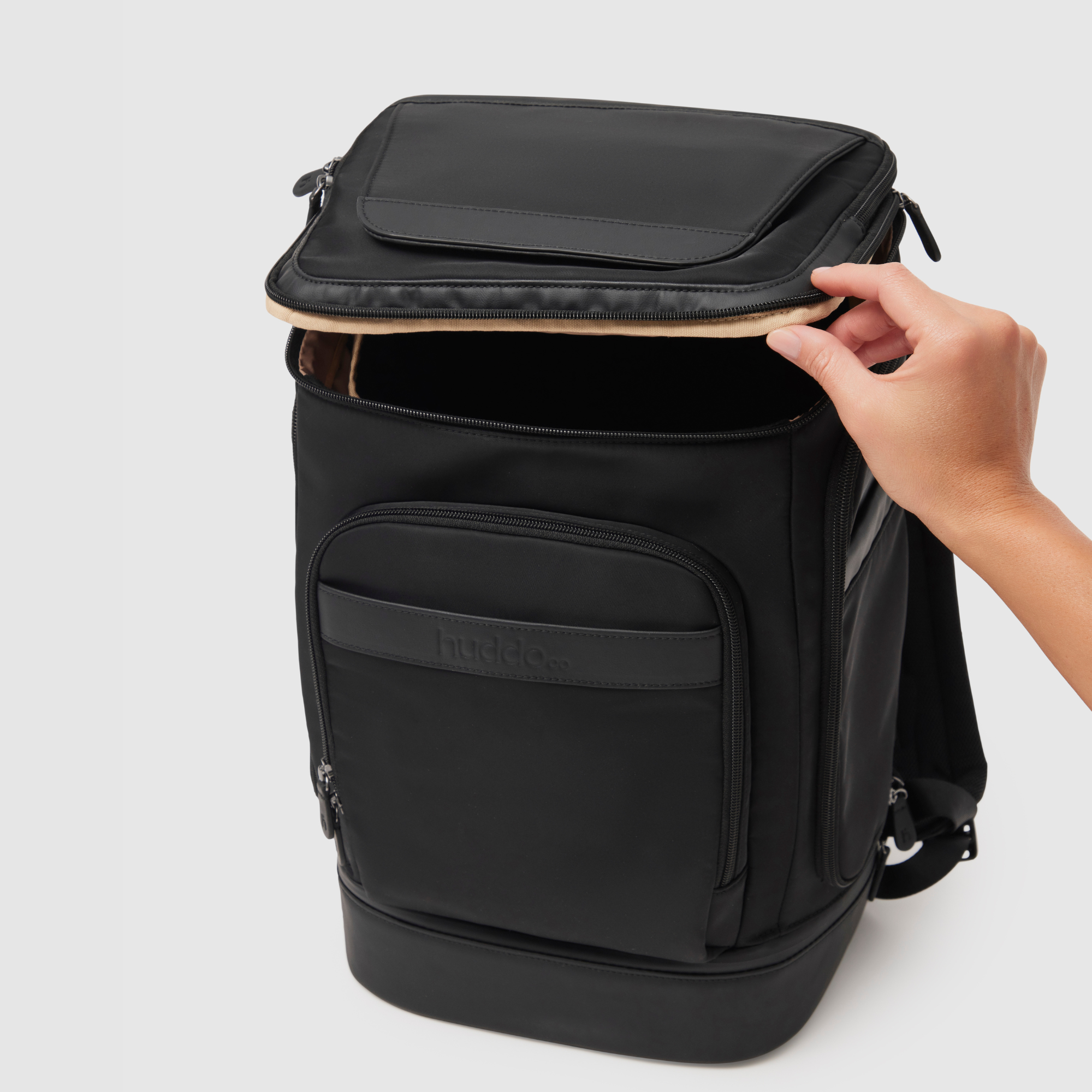 hand opening top access to main compartment of anywhere baby backpack - featuring pineapple leather and recycled nylon materials