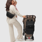mother and toddler looking at anywhere baby backpack on pram using stroller straps - mother is wearing nappy buddy belt bag