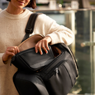 woman putting nappy buddy belt bag into side pocket of anywhere baby backpack