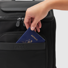 hand pulling passport from fron slip pocket of anywhere baby backpack - featuring close up of waterproof recycled nylon featuring pineapple leather accent