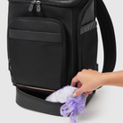 person putting soiled nappy or diaper into waterproof and odour-proof pocket on huddoco anywhere baby backpack