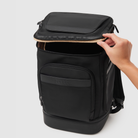 hand opening top access to main compartment of anywhere baby backpack - featuring pineapple leather and recycled nylon materials