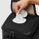 person taking baby wipe from wipes dispenser on anywhere baby backpack - refillable wipes case